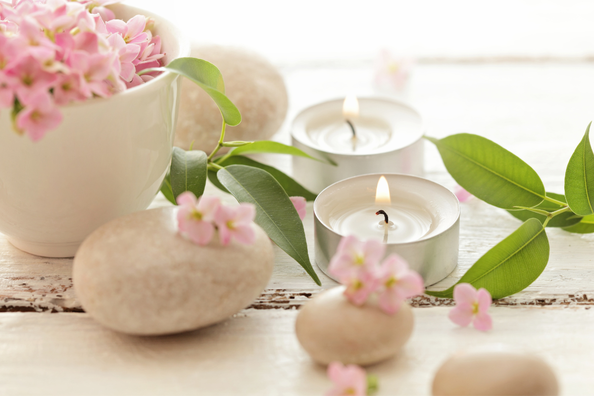 Scented Candle beside smooth stones